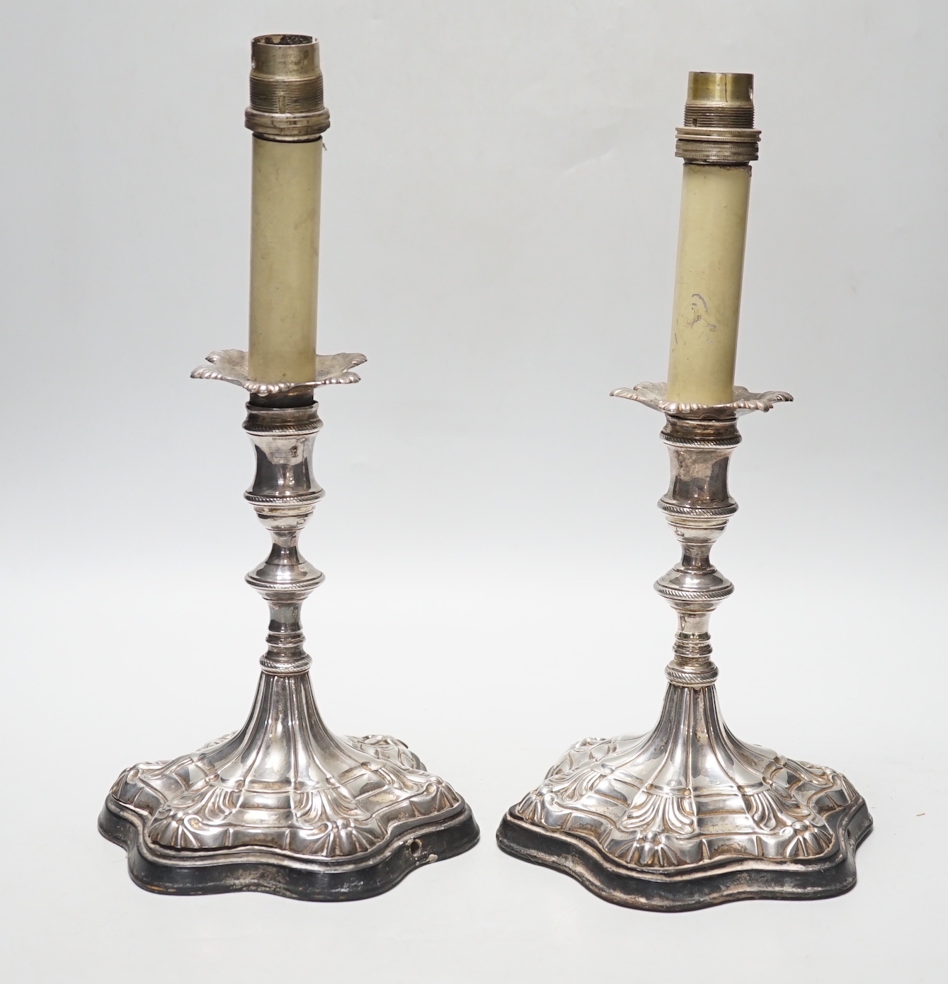 A pair of Georgian? silver candlesticks, on later wooden bases which have been drilled for electricity and later plated? sconces, sticks only, excluding sconces, are 16cm.